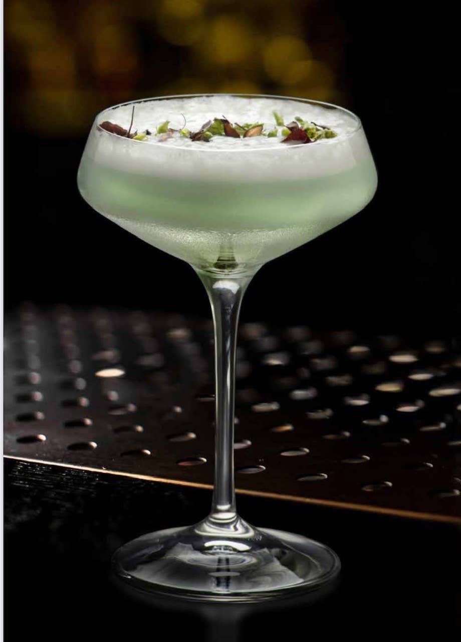 Champagnekupa i kristall med en cocktail i.